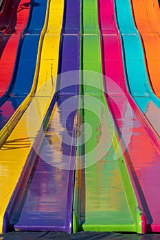 Close up abstract view of a large giant slide at the fairgrounds in rainbow colors