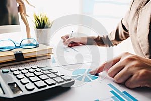 Close up of accountant hand holding pen working on calculator to calculate business financial reports