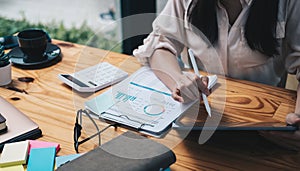 Close up Accounting woman using digital tablet with pen stylus on working space, business financial concept