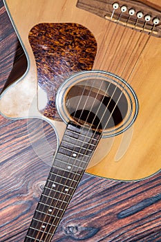 Close up of acoustic guitar. Acoustic guitar against an old wooden background