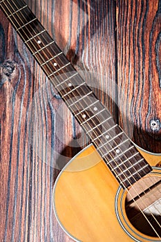 Close up of acoustic guitar. Acoustic guitar against an old wooden background