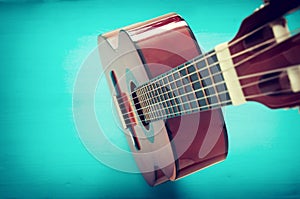 Close up of acoustic guitar against a wooden background