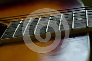 close up of an acoustic guitar in focus with the frets