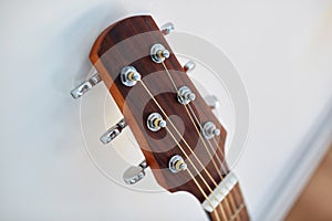 close up of acoustic guitar head with pegs