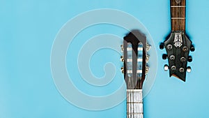 Close-up of acoustic guitar neck on blue background