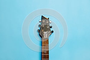 Close-up of acoustic guitar neck on blue background