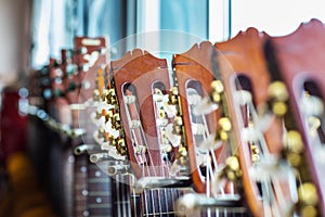 Close up of acoustic guitar necks on blurry background.