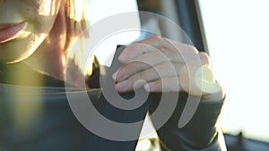 Close-up of action girl fastens a seat belt in a car before dropping off. Safe driving concept