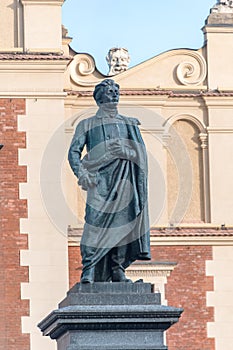 Close-up of Adam Mickiewicz Monument with Cloth Hall in background in Krakow, Poland