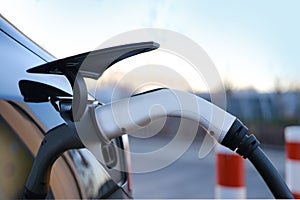 Close-up adapter with electric vehicle cables, part of black car charging energy, replenish battery charging station, alternative
