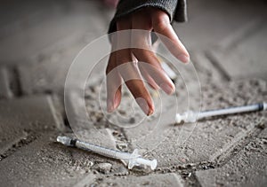 Close up of addict woman hands and drug syringes