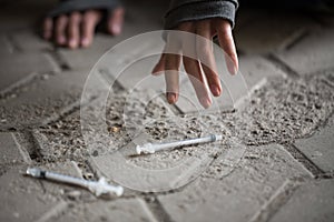 Close up of addict woman hands and drug syringes