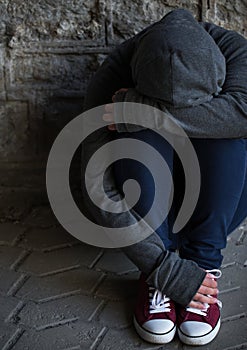 Close up of addict woman hiding her face on street