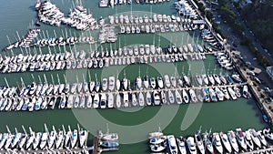 Close-up aerial video of Sausalitos marina, densely packed with sailboats and yachts, reflecting the leisurely seaside