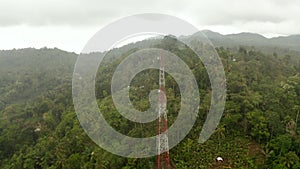 Close up aerial view of broadcast radio tower in the jungle. Wireless communications infrastructure in the Bali