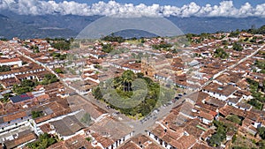 Close-up aerial view of historic town Barichara, Colombia situated on a cliff edge, in the center green plaza and cathedral