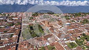 Close-up aerial view of historic town Barichara, Colombia situated on a cliff edge, in the center green plaza and cathedral