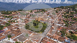 Close-up aerial view of historic town Barichara, Colombia situated on a cliff edge, in the center green plaza and cathedral