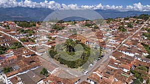 Close-up aerial view of historic town Barichara, Colombia situated on a cliff edge, in the center green plaza and cathedral