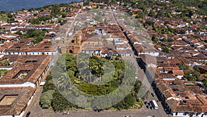 Close-up aerial view of historic town Barichara, Colombia situated on a cliff edge, in the center green plaza and cathedral