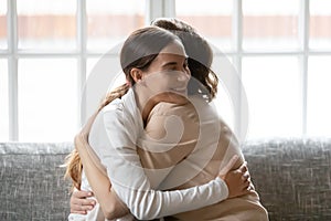 Close up affectionate grownup daughter hugging middle aged mother