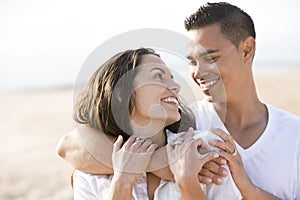 Close up of affectionate Hispanic couple on beach photo