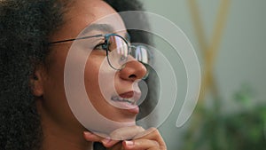 Close up African American business woman in eyeglasses looking away thinking smiling thoughtful ethnic girl happy
