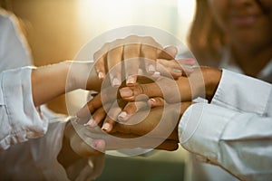 Close up of african-american and caucasian human`s hands holding on wooden table