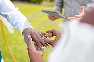Close up of african american couple putting ring during wedding