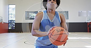 Close up of african american male basketball player shooting ball at indoor court, slow motion