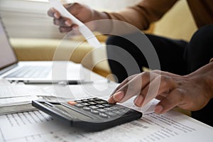 Close up of african american man with calculator checking bills photo