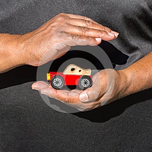 Close up of African American man`s hands cupped around a toy car