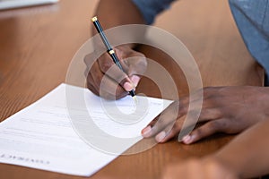 Close up African American man signing contract, legal documents