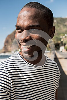 Close up african american man in striped teeshirt smiling and looking away photo