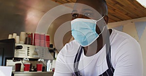 Close up of african american man wearing face mask taking order at the food truck