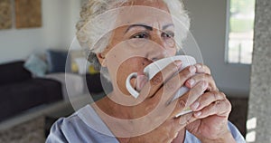 Close up of african american senior woman drinking coffee at home
