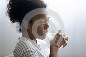 Close up African American woman enjoying drinking pure mineral water