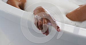 Close up of african american woman relaxing in the bath tub in the bathroom at home