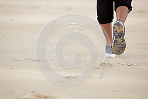 Close up african american woman walking on sand at the beach