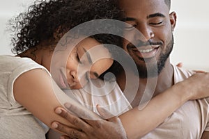 Close up african couple embracing closed eyes enjoy tender moment