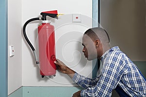 Male Professional Checking A Fire Extinguisher photo