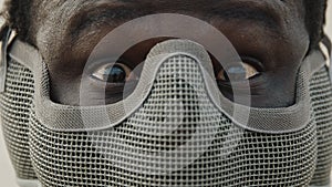 Close up, african man with mask over his face and red surprised or scared eyes