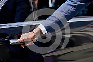 Close-up of african man`s hand opening the door of car