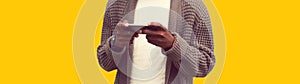 Close up of african man with smartphone isolated on yellow background