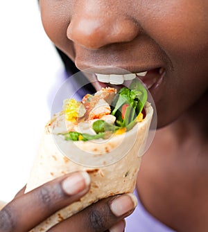 Close up of an african woman devouring a burrito photo