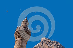 Close up of Afyon Kalesi with pigeons birds and minaret photo