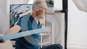 Close up of aged person pulling resistance band to exercise