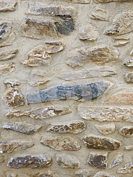 Close up on aged stone wall surface of grey colours. Vertical photo