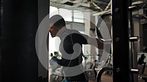 Close-up of an aggressive caucasian man hitting a punching bag in a gym