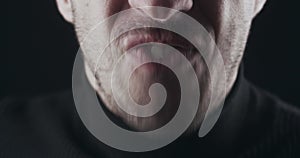 Close-up of aggressive man's mouth screams and threatens with violence. Macro shot of mad boss shows anger at employees